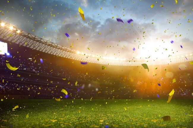 Imagem de estádio de futebol com confetti a cair sobre o relvado